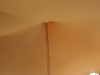 Stijlvolle feesttent met beige stretchdoek en houten palen
